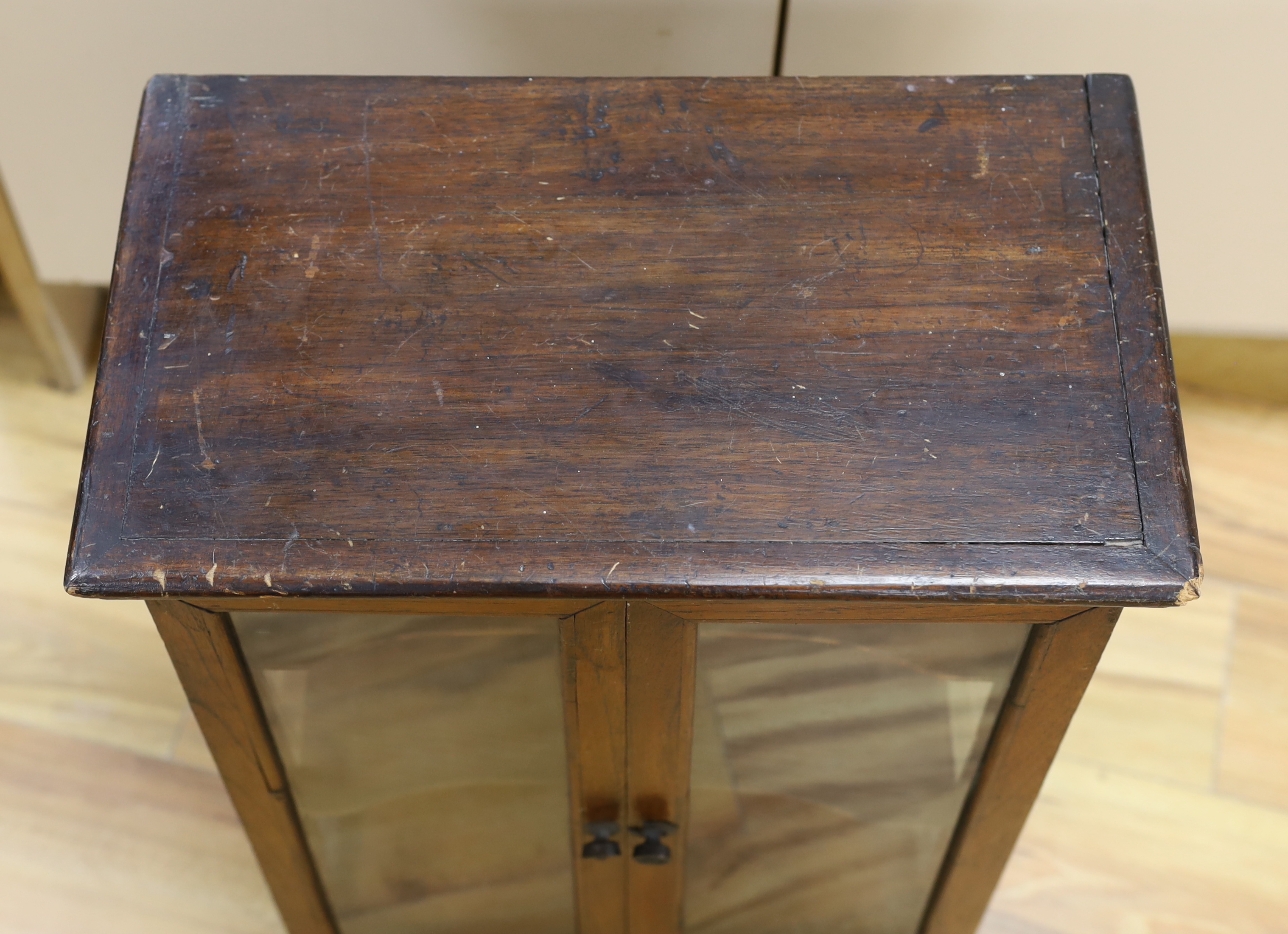 A small early 20th century glazed oak and pine two door shop display cabinet, 65.5 x 45 x 26cm